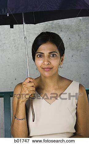Portrait of a businesswoman holding an umbrella View Large Photo Image Stock Photo - Portrait of a businesswoman holding an umbrella. Fotosearch