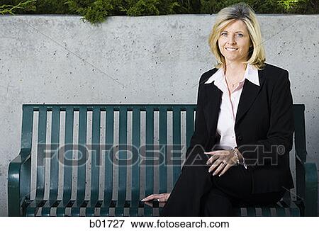 Portrait of a businesswoman sitting on a bench View Large Photo Image Stock Photo - Portrait of a businesswoman sitting on a bench. Fotosearch