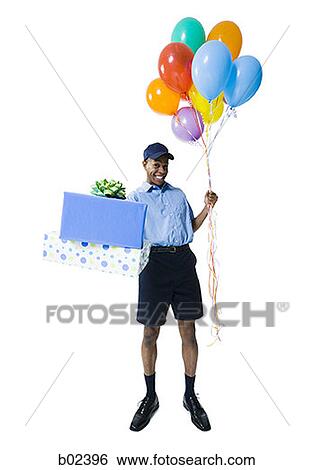Portrait of a delivery man holding gifts and balloons View Large Photo Image Stock Photograph - Portrait of a delivery man holding gifts and balloons. Fotosearch