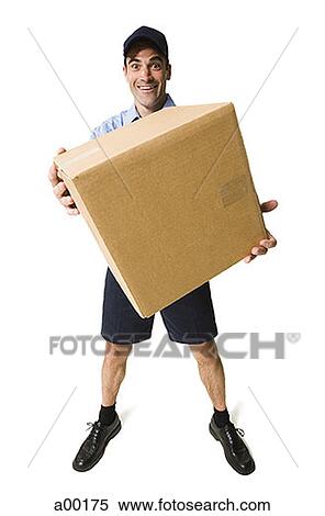 Portrait of a delivery man standing holding a box View Large Photo Image Stock Photography - Portrait of a delivery man standing holding a box. Fotosearch