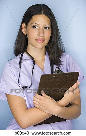 Portrait of a female nurse holding a clipboard View Large Photo Image Stock Image - Portrait of a female nurse holding a clipboard. Fotosearch