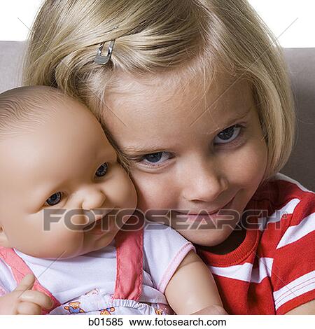 Portrait of a girl holding a doll View Large Photo Image Stock Photography - Portrait of a girl holding a doll. Fotosearch