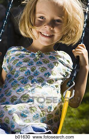 Portrait of a girl sitting on a swing View Large Photo Image Stock Image - Portrait of a girl sitting on a swing. Fotosearch
