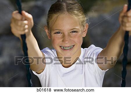 Portrait of a girl sitting on a swing View Large Photo Image Stock Photo - Portrait of a girl sitting on a swing. Fotosearch
