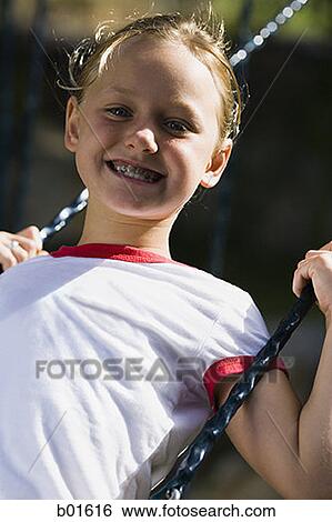 Portrait of a girl sitting on a swing View Large Photo Image Stock Photograph - Portrait of a girl sitting on a swing. Fotosearch