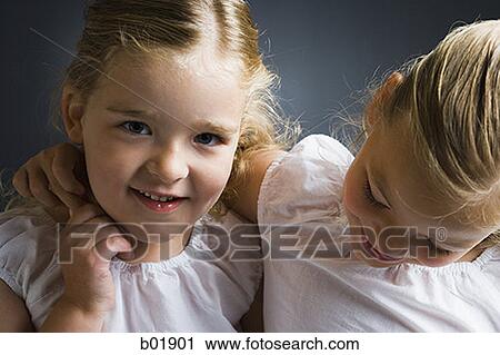 Portrait of a girl smiling with her sister View Large Photo Image Stock Image - Portrait of a girl smiling with her sister. Fotosearch