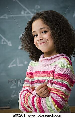 Portrait of a girl standing in front of a blackboard View Large Photo Image Stock Image - Portrait of a girl standing in front of a blackboard. Fotosearch