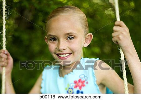 Portrait of a girl swinging on a swing View Large Photo Image Stock Photo - Portrait of a girl swinging on a swing. Fotosearch