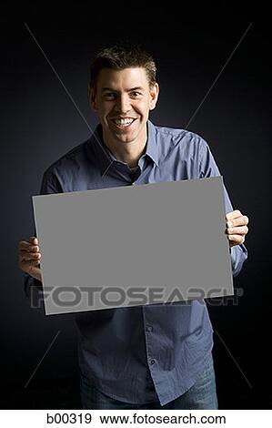 Portrait of a man holding a blank sign View Large Photo Image Stock Photo - Portrait of a man holding a blank sign. Fotosearch