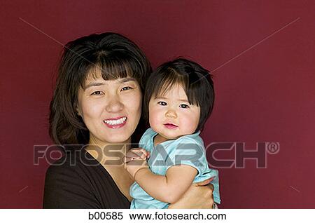 Stock Photography - Portrait of a mother carrying her daughter. Fotosearch