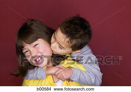 Picture - Portrait of a sister being kissed by her brother. Fotosearch