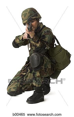Stock Photography - Portrait of a soldier crouching and aiming his rifle. Fotosearch
