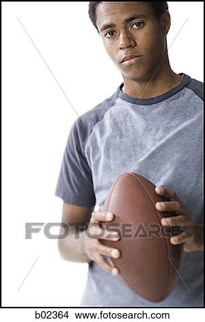 Portrait of a teenage boy holding a football View Large Photo Image Picture - Portrait of a teenage boy holding a football. Fotosearch
