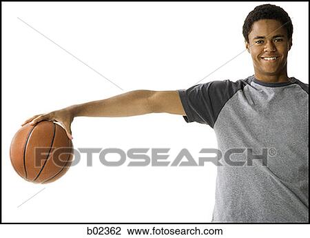 Stock Image - Portrait of a teenage boy holding a basketball. Fotosearch