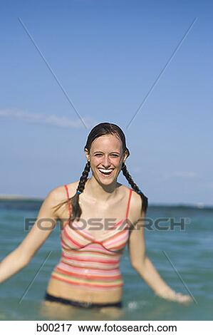 Stock Photo - Portrait of a teenage girl standing in water and smiling. Fotosearch