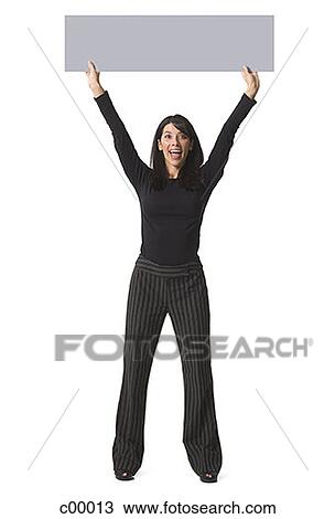 Stock Image - Portrait of a woman lifting up a blank sign. Fotosearch