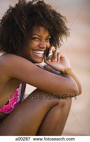 Portrait of a young African-American woman using a mobile phone View Large Photo Image Stock Photo - Portrait of a young African-American woman using a mobile phone. Fotosearch