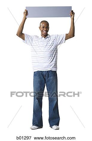 Portrait of a young African-American man holding a blank sign over his head View Large Photo Image Stock Photo - Portrait of a young African-American man holding a blank sign over his head. Fotosearch