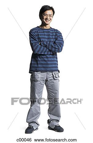 Stock Photograph - Portrait of a young Asian man standing with his arms crossed. Fotosearch