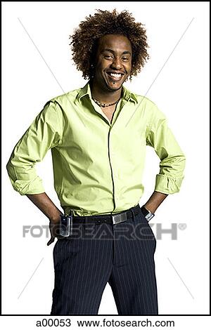 Stock Image - Portrait of a young Black man standing with hands on hips. Fotosearch