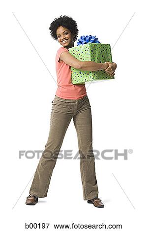 Portrait of a young black woman holding a gift View Large Photo Image Stock Photo - Portrait of a young black woman holding a gift. Fotosearch