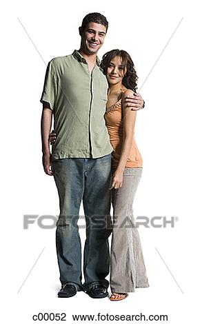 Portrait of a young couple standing with arms around View Large Photo Image Stock Image - Portrait of a young couple standing with arms around. Fotosearch