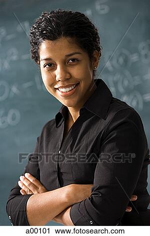 Portrait of a young female teacher smiling with her arms folded View Large Photo Image Stock Image - Portrait of a young female teacher smiling with her arms folded. Fotosearch