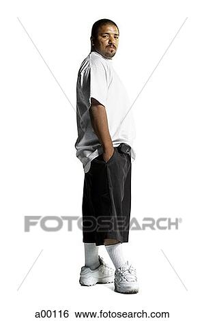 Stock Photograph - Portrait of a young Latin homeboy standing with hands in his pockets. Fotosearch