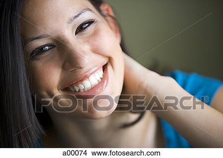 Portrait of a young Latin woman with her hand on her neck View Large Photo Image Picture - Portrait of a young Latin woman with her hand on her neck. Fotosearch
