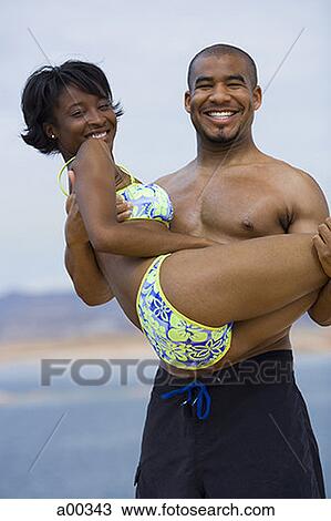 Portrait of a young man carrying a young woman View Large Photo Image Stock Image - Portrait of a young man carrying a young woman. Fotosearch