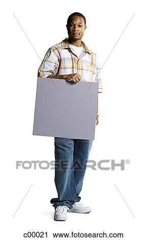 Portrait of a young man holding a blank sign View Large Photo Image Stock Image - Portrait of a young man holding a blank sign. Fotosearch