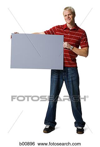 Portrait of a young man holding a blank sign View Large Photo Image Stock Photograph - Portrait of a young man holding a blank sign. Fotosearch