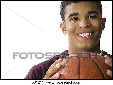 Portrait of a young man holding a basketball View Large Photo Image Stock Image - Portrait of a young man holding a basketball. Fotosearch