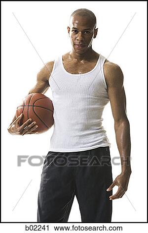 Portrait of a young man holding a basketball View Large Photo Image Stock Image - Portrait of a young man holding a basketball. Fotosearch