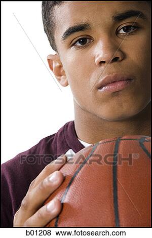 Portrait of a young man holding a basketball View Large Photo Image Stock Photo - Portrait of a young man holding a basketball. Fotosearch