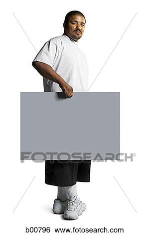 Portrait of a young man holding a placard View Large Photo Image Stock Photograph - Portrait of a young man holding a placard. Fotosearch