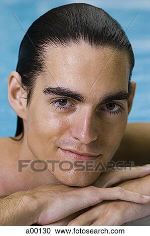 Stock Image - Portrait of a young man in a swimming pool. Fotosearch