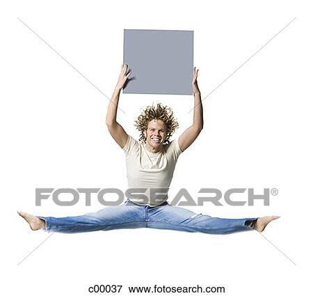 Portrait of a young man jumping, doing a split, and holding a blank sign View Large Photo Image Stock Photo - Portrait of a young man jumping, doing a split, and holding a blank sign. Fotosearch