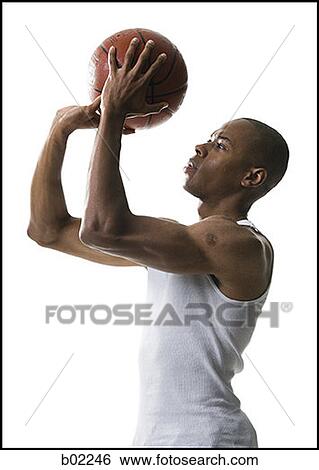 Portrait of a young man shooting a basketball View Large Photo Image Stock Photograph - Portrait of a young man shooting a basketball. Fotosearch