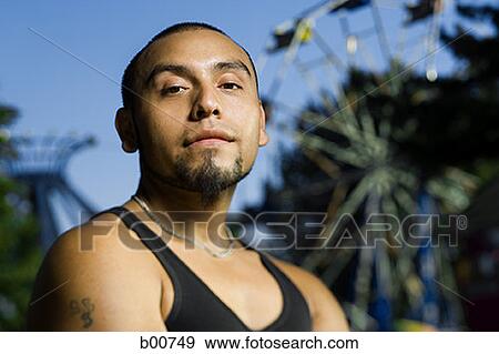 Stock Photo - Portrait of a young man standing in an amusement park. Fotosearch