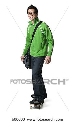 Portrait of a young man standing on a skateboard View Large Photo Image Stock Image - Portrait of a young man standing on a skateboard. Fotosearch