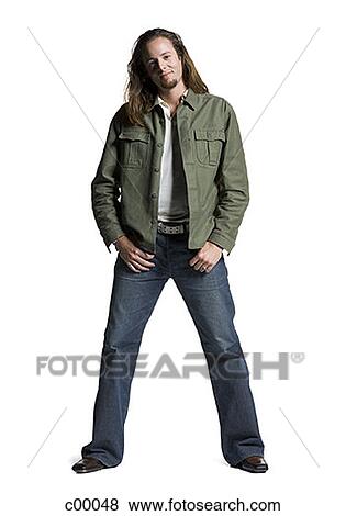 Portrait of a young man standing with hands in his pockets View Large Photo Image Stock Photo - Portrait of a young man standing with hands in his pockets. Fotosearch