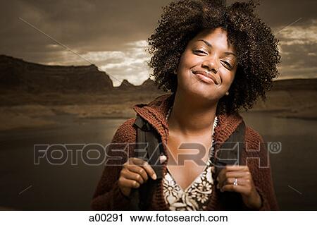 Portrait of a young woman carrying a backpack View Large Photo Image Stock Image - Portrait of a young woman carrying a backpack. Fotosearch