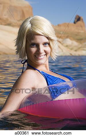 Portrait of a young woman floating on a raft View Large Photo Image Stock Image - Portrait of a young woman floating on a raft. Fotosearch
