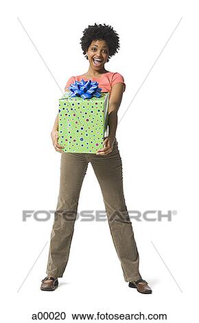 Portrait of a young woman holding a gift View Large Photo Image Stock Image - Portrait of a young woman holding a gift. Fotosearch