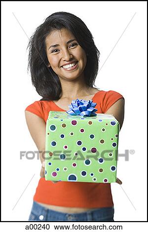 Portrait of a young woman holding a gift View Large Photo Image Stock Image - Portrait of a young woman holding a gift. Fotosearch