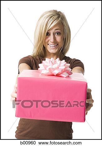 Portrait of a young woman holding a gift View Large Photo Image Stock Image - Portrait of a young woman holding a gift. Fotosearch