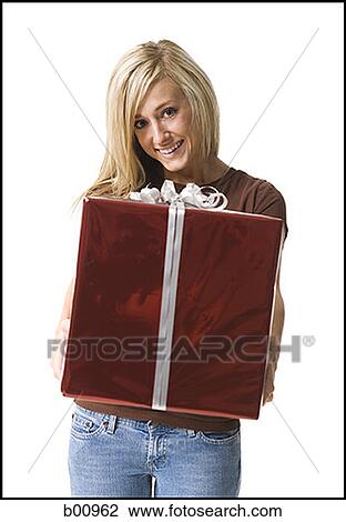 Portrait of a young woman holding a gift View Large Photo Image Stock Image - Portrait of a young woman holding a gift. Fotosearch