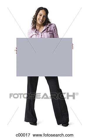 Portrait of a young woman holding a blank sign View Large Photo Image Stock Photo - Portrait of a young woman holding a blank sign. Fotosearch