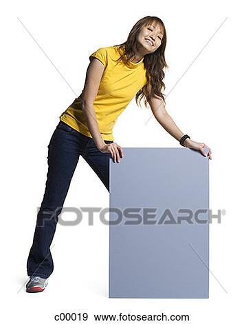 Stock Photo - Portrait of a young woman holding a blank sign. Fotosearch